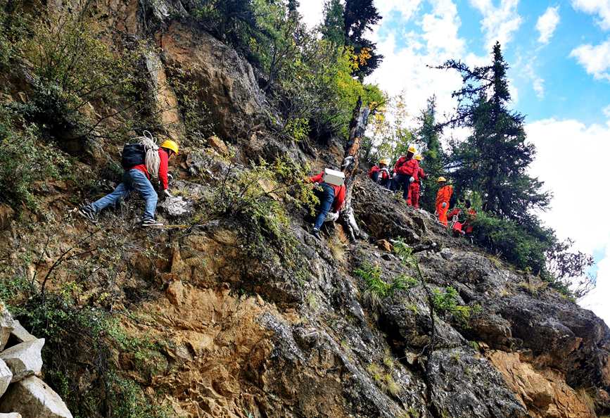 9月17日，电力施工人员正在悬崖峭壁间运输工器具和安全文明设施。次仁桑布摄